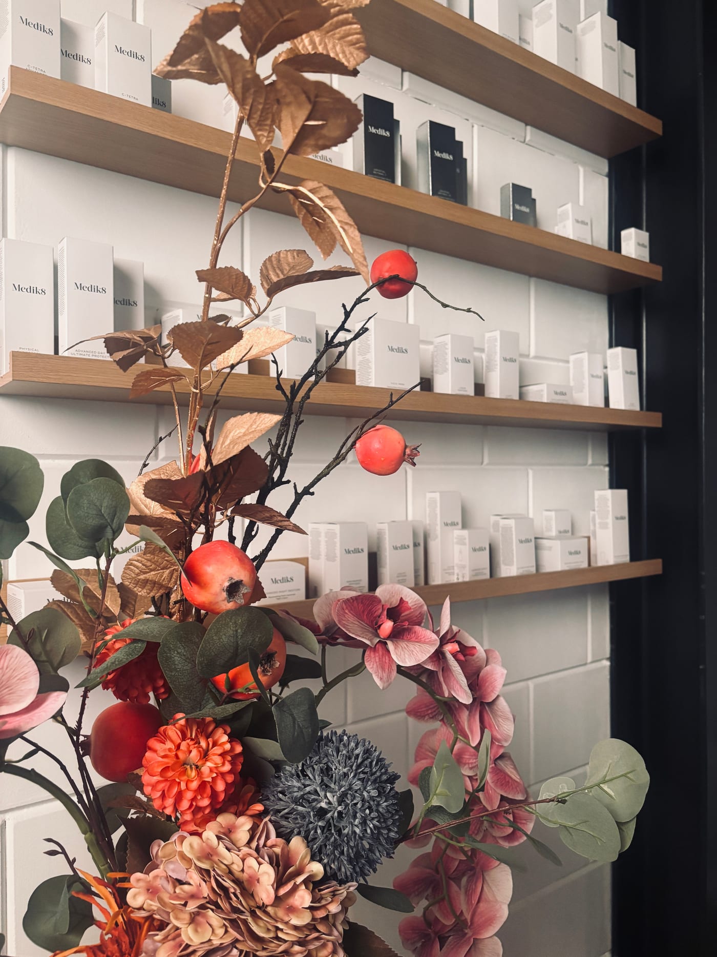 Schap in de salon met bloemen en Medik8-producten